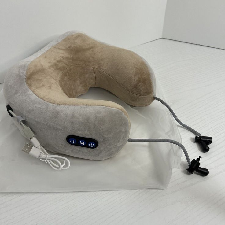 Gray and beige neck pillow with USB cable on a white background