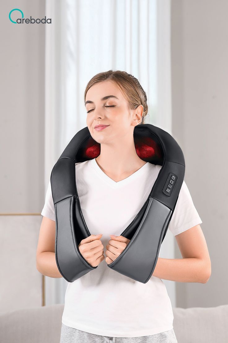 Woman using a neck and shoulder massager with a neutral background